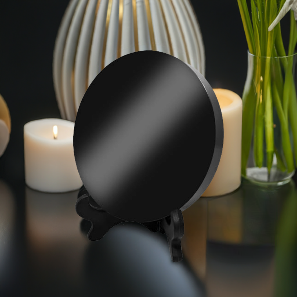 An obsidian mirror sits on a table among candles and flowers