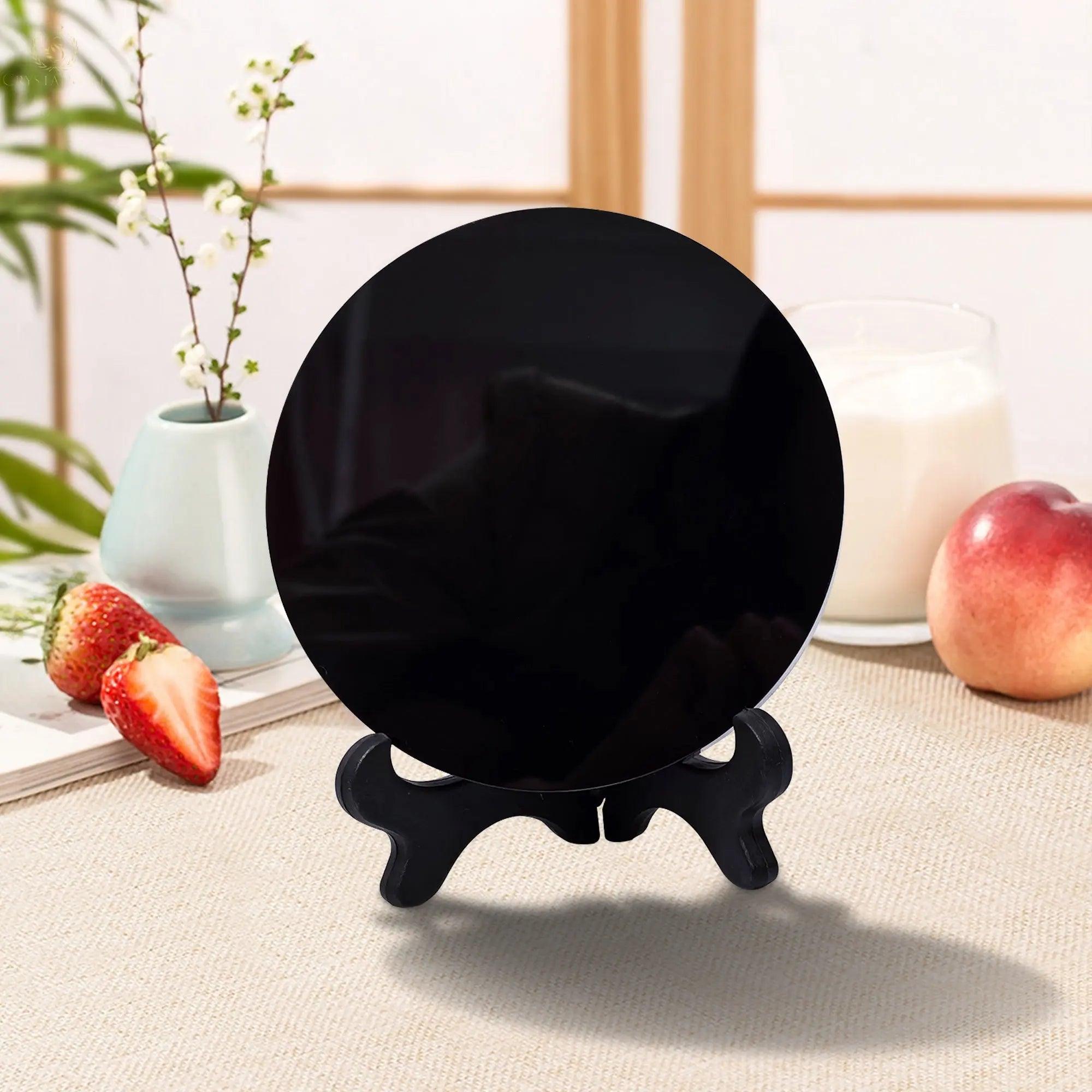 Natural black obsidian scrying mirror on a wooden stand